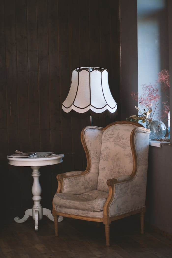 Mastering the First Impression: Your intriguing post title goes here Charming vintage interior with an armchair, elegant lamp, and side table. Perfect for cozy settings.